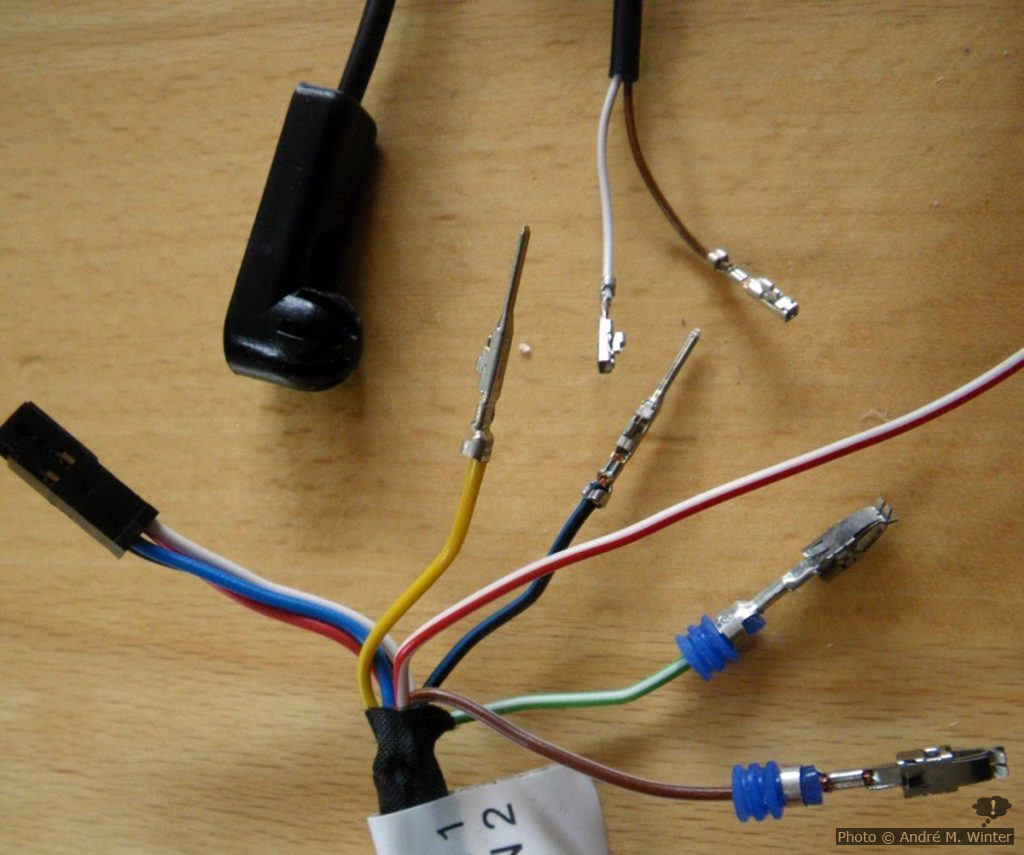 Oben links der 4-polige Stecker zum Steuergerät. Oben rechts der Temperatursensor ohne dem das Gerät nicht geht (ausser man schliesst einen passenden Widerstand an, aber dies ist nirgends dokumentiert. Da ich die Montage im Hochsommer machte, steckte ich das Teil in einen Plastiksack und diesen in ein Glas mit Eiswürfel um die Heizung testweise starten zu können... Darunter die dünnen Steckverbindungen für den Temperatursensor. Hierfür gibt es auch einen Kunststoffstecker. Polarität egal. Links unten Stecker für Testzwecke, undokumentiert.