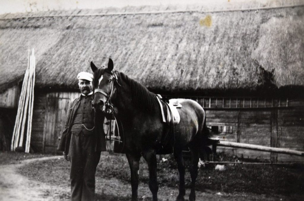 Karl mit Pferd vor reetgedecktem Haus im Sommer 1932