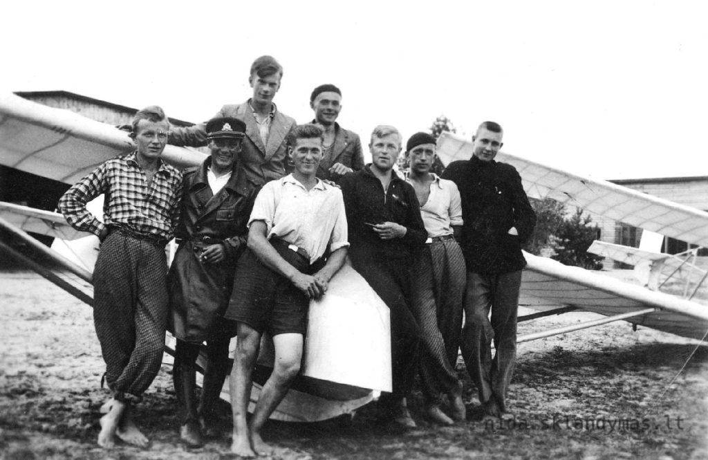 Gregor und andere vor Flieger vor dem Hangar und dem Heim in Nida