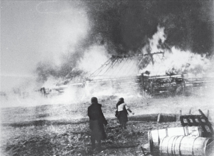 Russen schauen zu während Deutsche ihre Häuser in Begoml niederbrennen