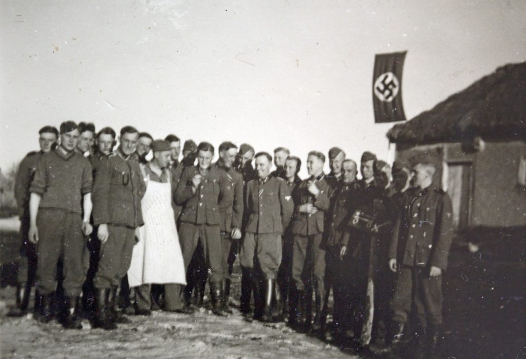 Waffen-SS-Soldaten posieren mit Hakenkreuzfahne in Weissrussland