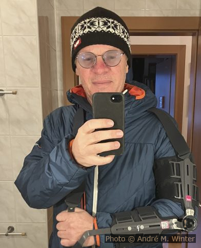 André mit Ellbogen-Orthese über dicker Winterjacke