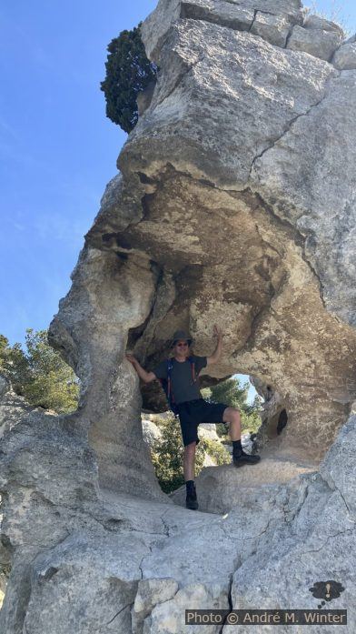 André in einem Fels mit Loch bei Les Baux. Photo: Alex Medwedeff